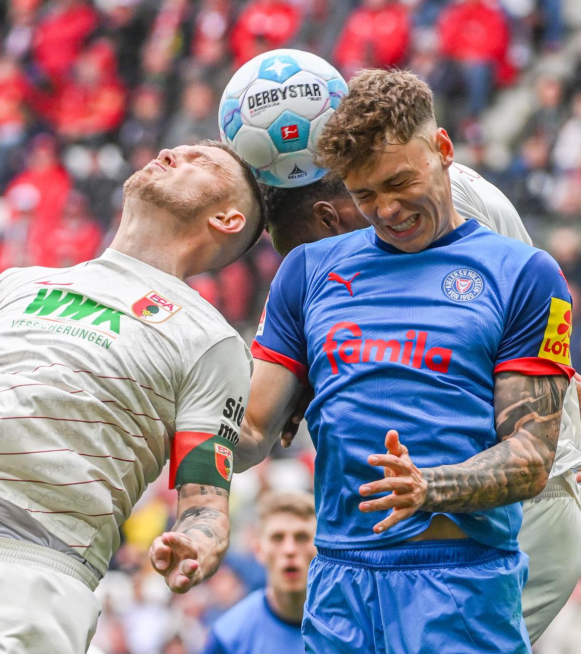 Nicolai Remberg von Kiel und Jeffrey Gouweleeuw von Augsburg im Kampf um den Ball.
