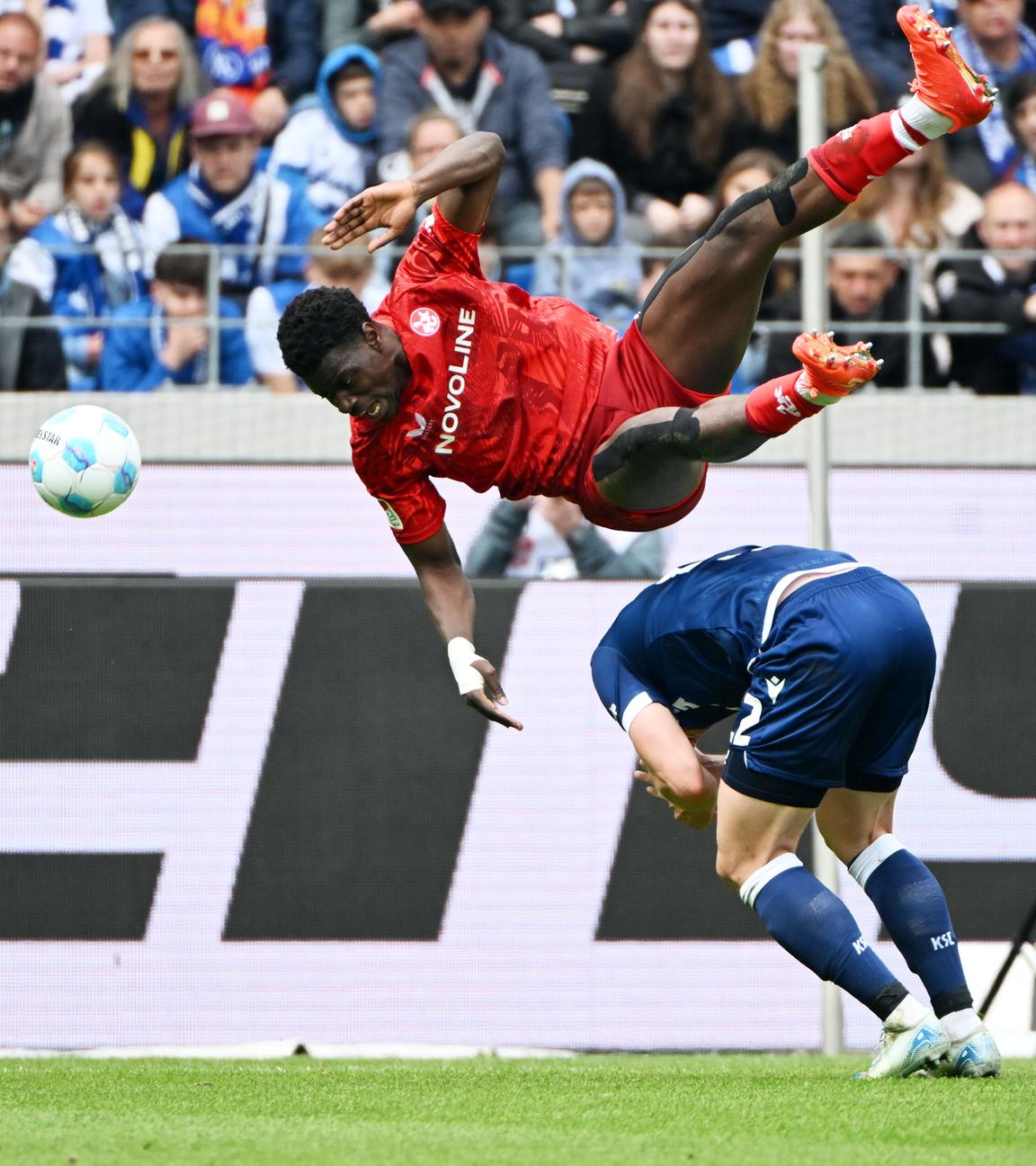 Der Karlsruher Christoph Kobald und der Lauterer Ragnar Ache kämpfen um den Ball.