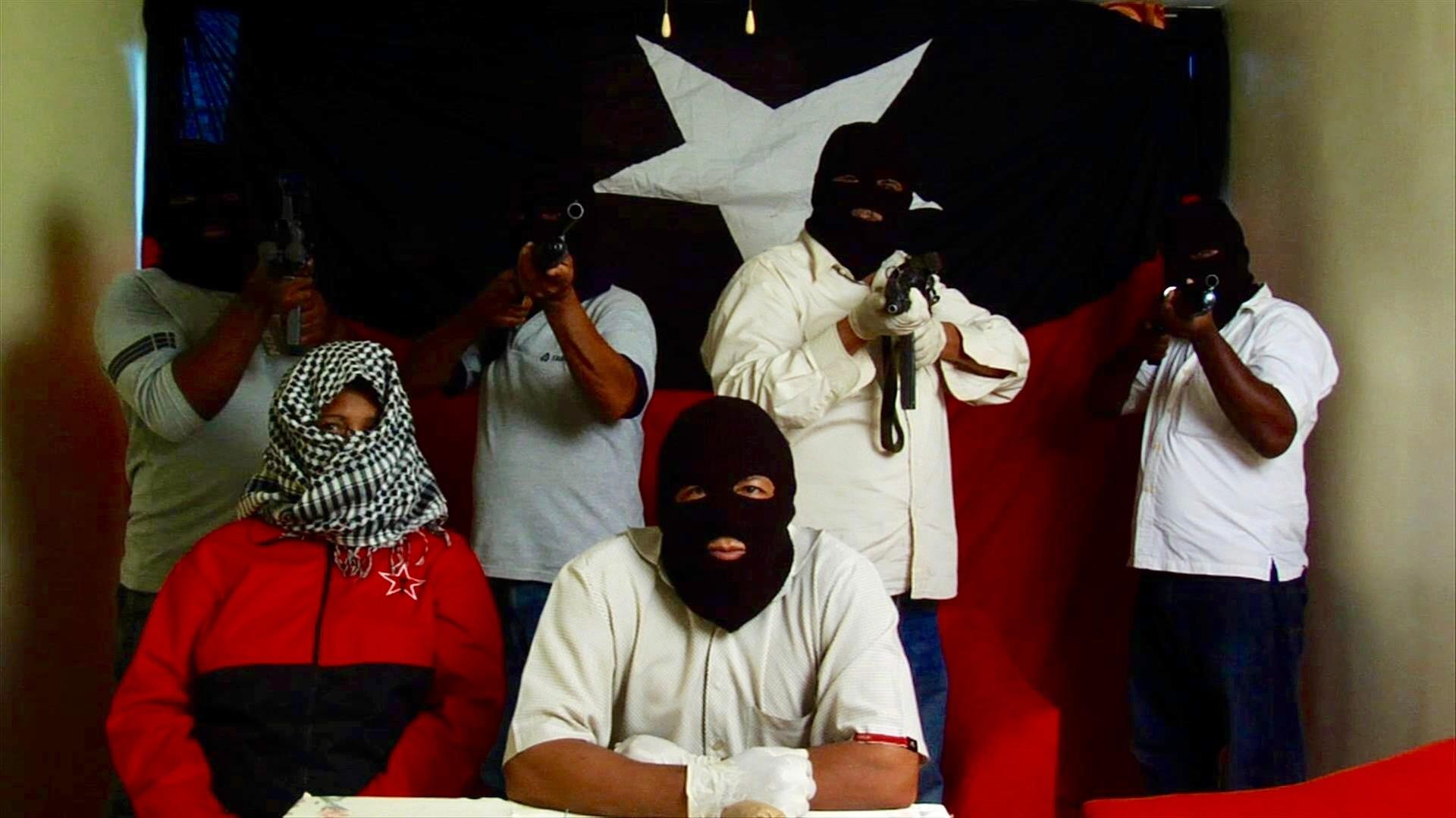 "Die Schlägertrupps des Präsidenten - Venezuela im Würgegriff von Stadtguerillas": Maskierte Männer mit Gewehren vor einer rot-blauen Flagge mit weißem Stern.