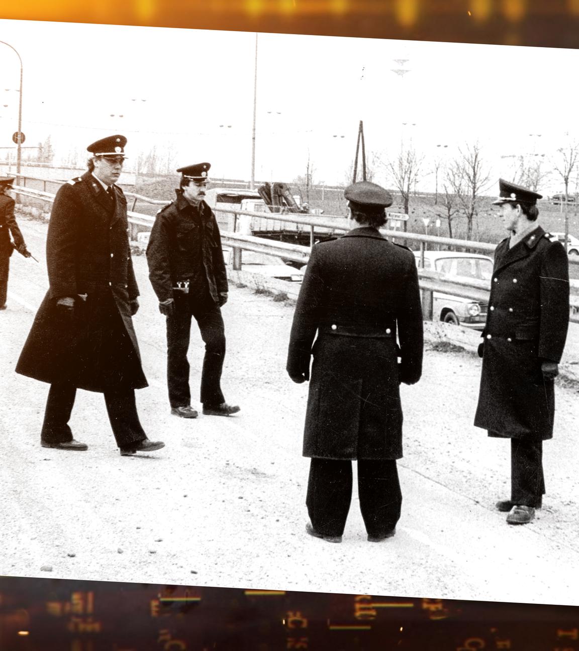 Mehrere uniformierte österreichische Polizisten stehen im Kreis auf einer Straße.