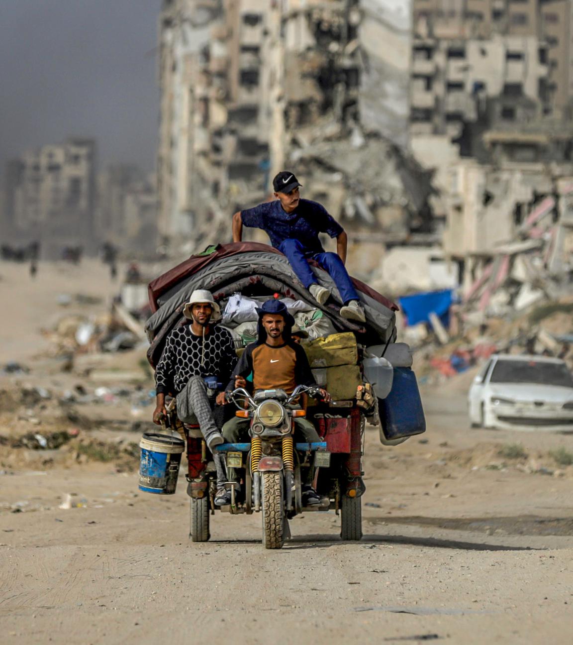 Bewohner des Gazastreifens auf eine überladenen Motorrad in Zentral Gaza am 17.05.2025.