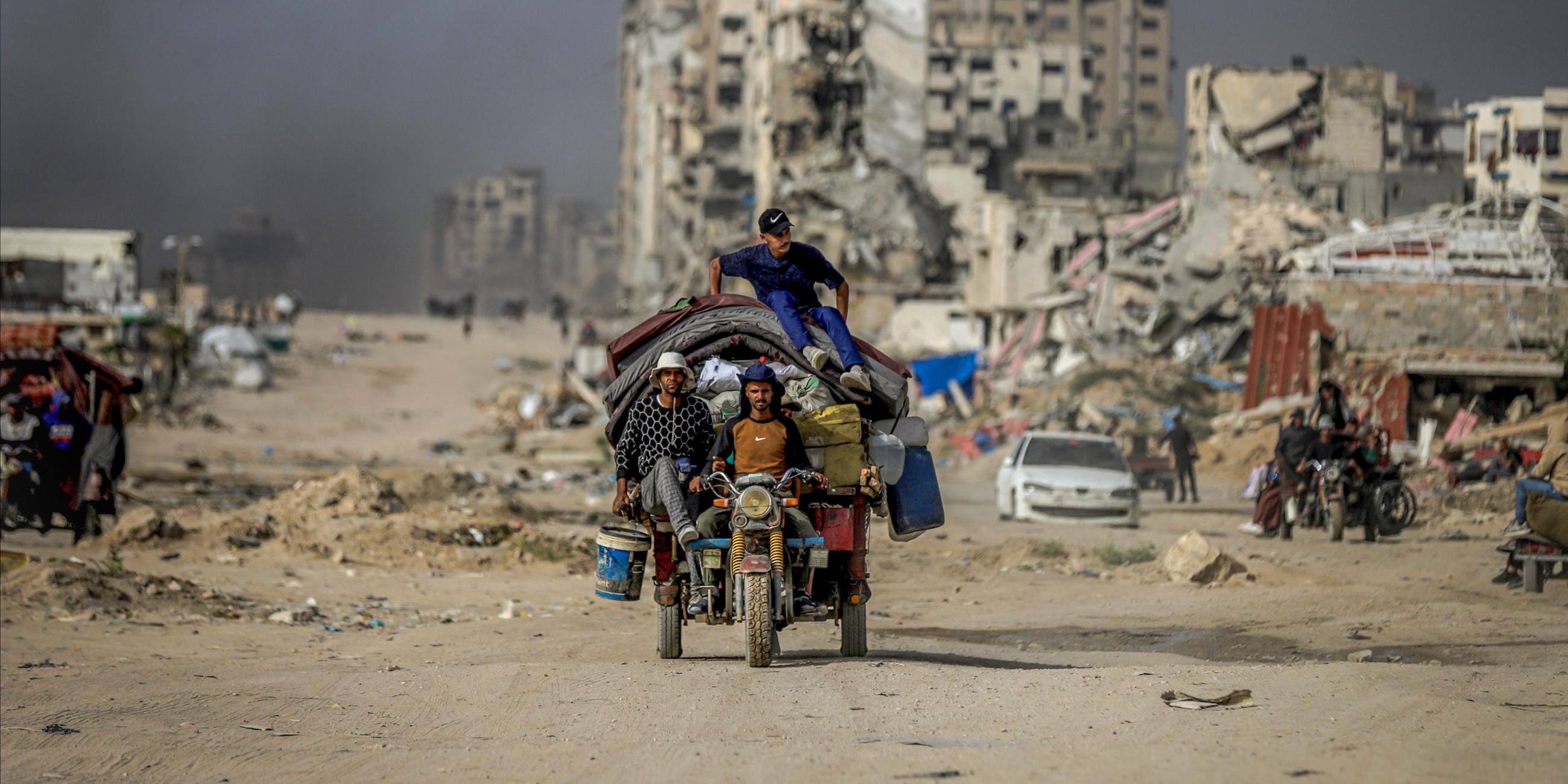 Bewohner des Gazastreifens auf eine überladenen Motorrad in Zentral Gaza am 17.05.2025.