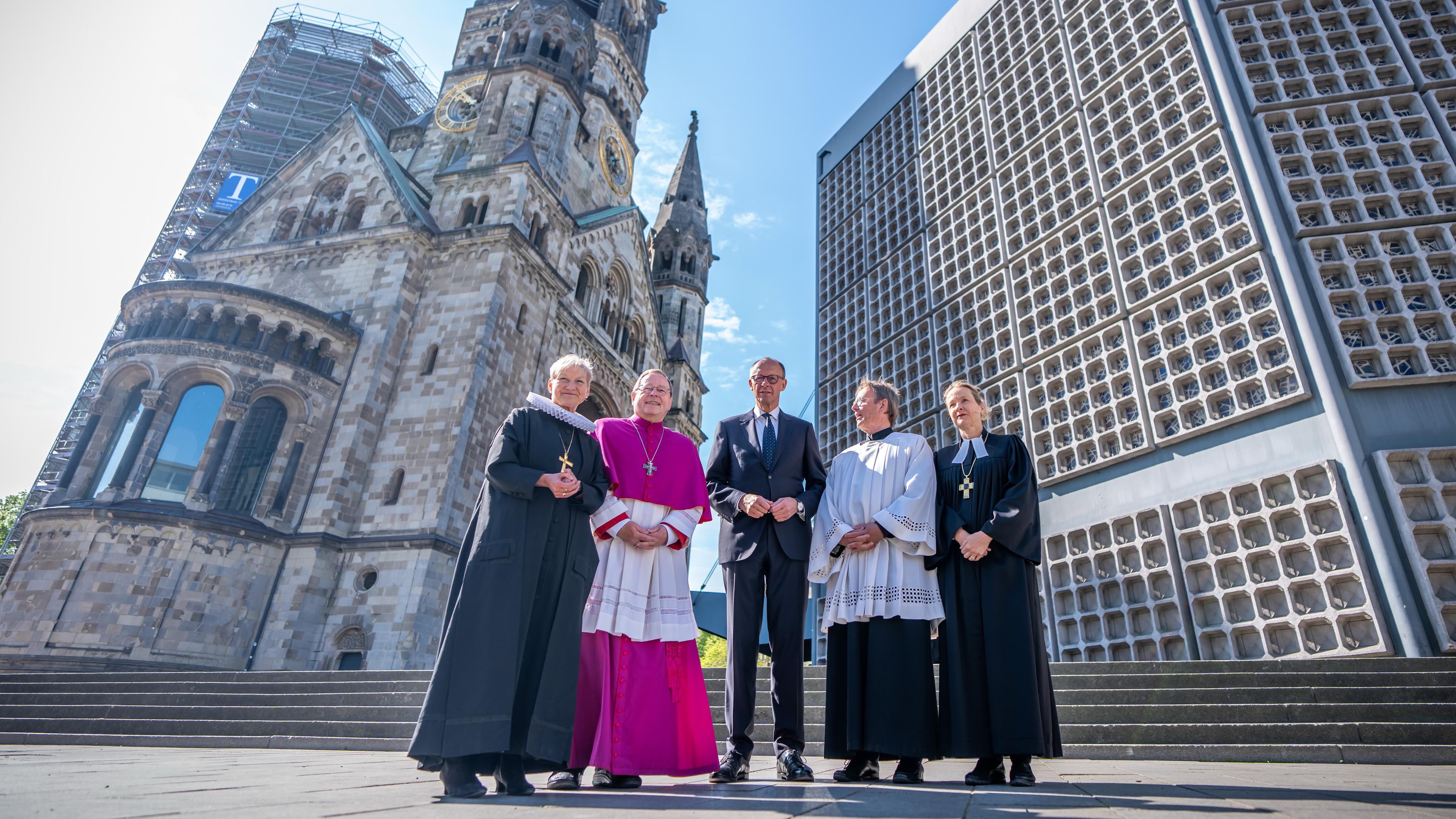 Friedrich Merz mit einer Bischhöfin, einem Bischof, einer Prälatin und einem Prälat vor der Gedächtniskirche in Berlin