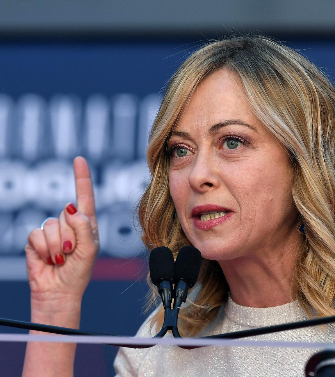 Italienische Regierungschefin Giorgia Meloni hebt den Zeigefinger der rechten Hand.