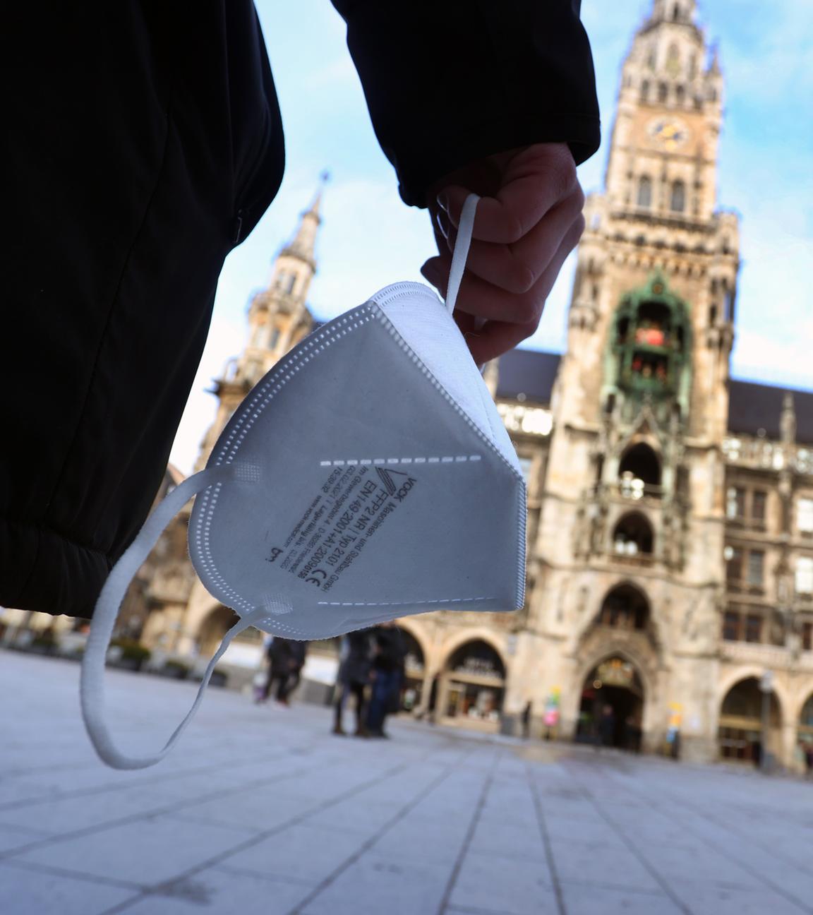 Bayern, München: Eine Frau hält auf dem Marienplatz eine FFP2 Maske. Archivbild