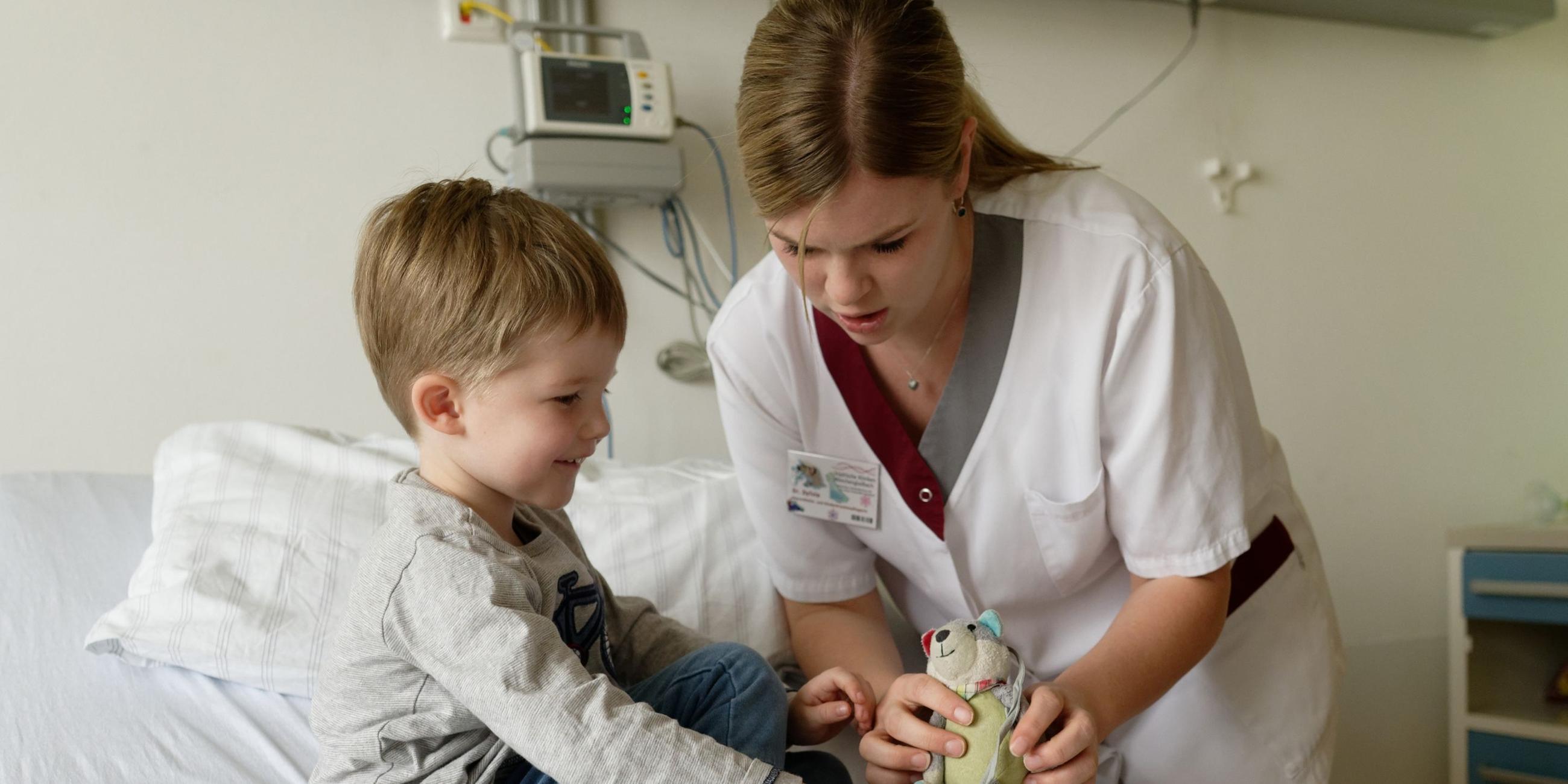 Kinderkrankenschwester mit jungem Patienten.