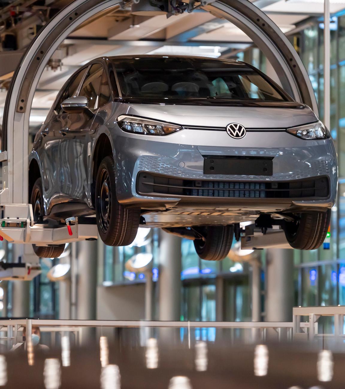 Ein Auto schwebt am Fließband durch die Montagehalle im VW-Produktionswerk.