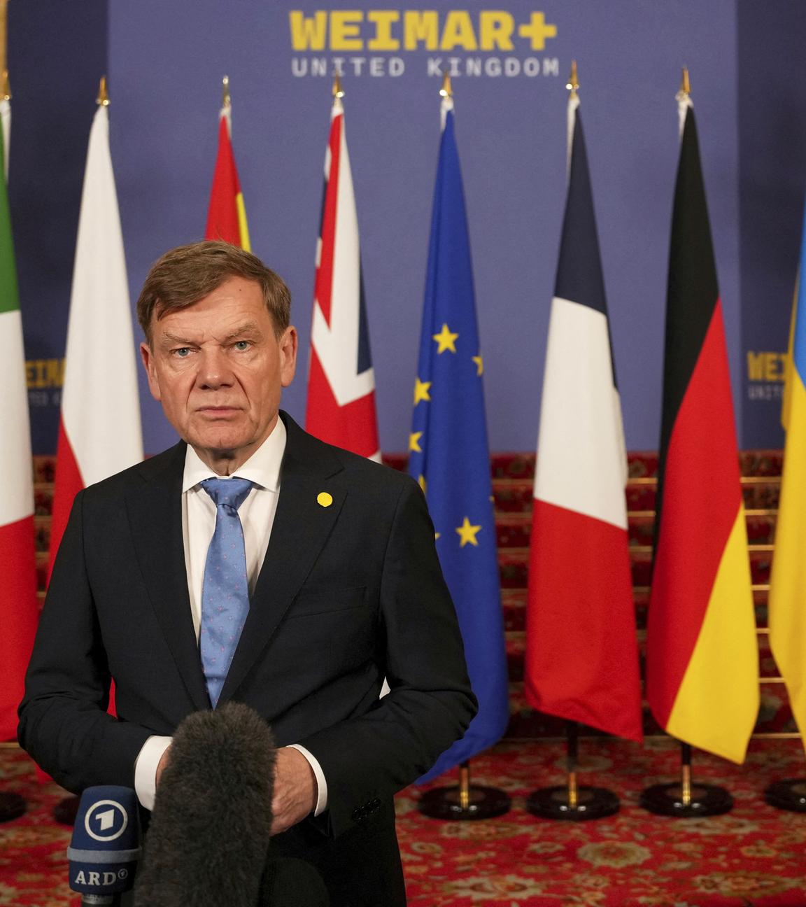 Außenminister Wadephul steht vor Flaggen bei einer Ukraine-Konferenz in London.
